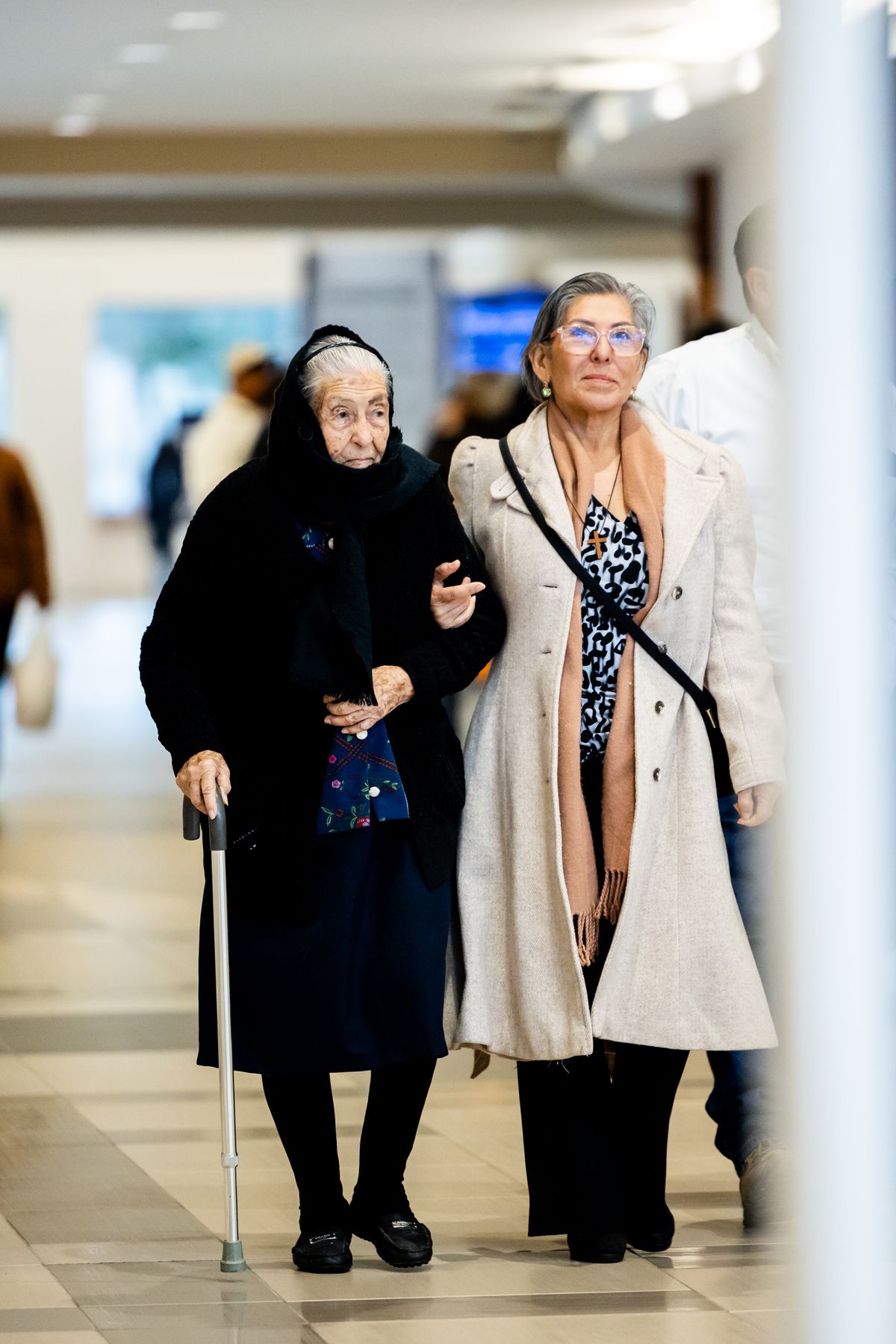 Elderly patient practicing walking with support during a home physiotherapy session